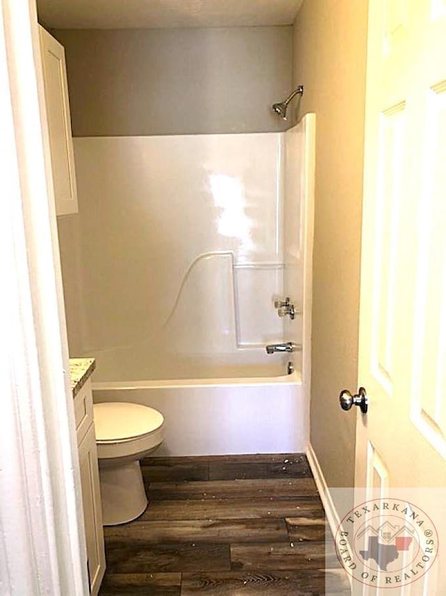 full bathroom featuring toilet, shower / washtub combination, wood finished floors, and vanity