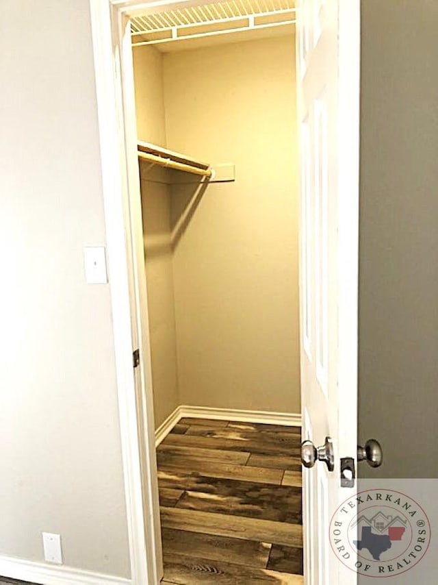 spacious closet featuring dark hardwood / wood-style flooring