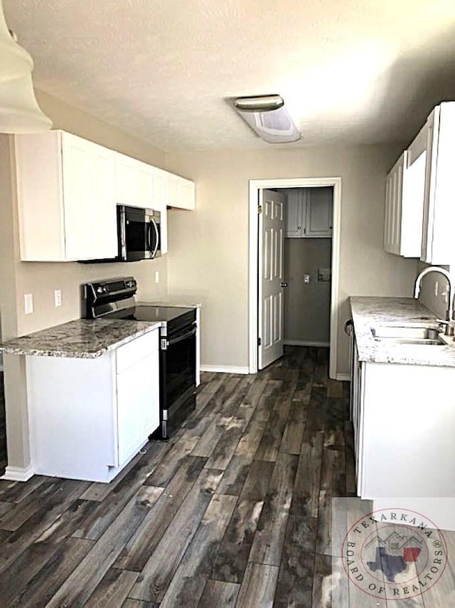 kitchen featuring white cabinets, appliances with stainless steel finishes, dark wood-type flooring, and sink