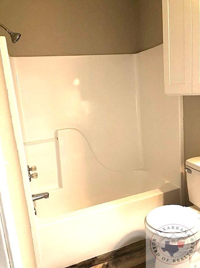 bathroom featuring shower / washtub combination and toilet