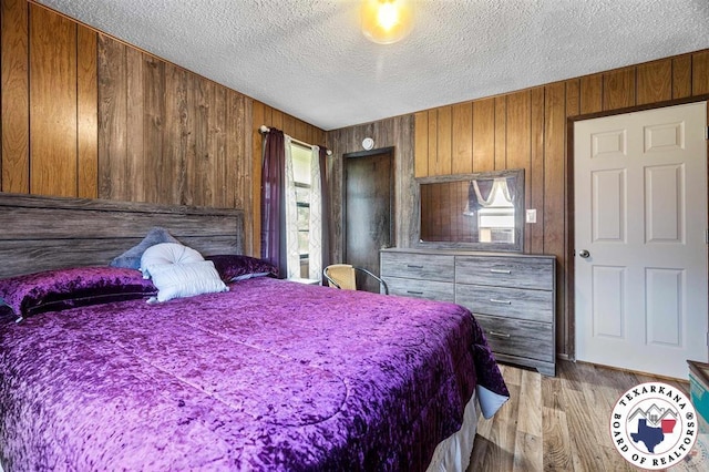 203 Pleasant Vly, Texarkana, AR 71854 - bedroom featuring a textured ceiling, wood walls, and light wood finished floors