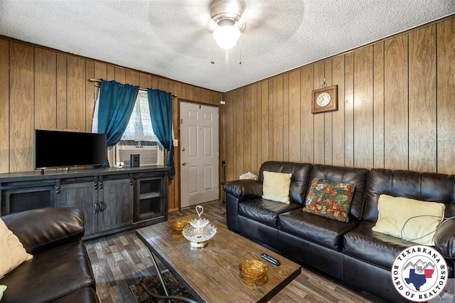 203 Pleasant Vly, Texarkana, AR 71854 - living area featuring a textured ceiling, wood walls, dark wood-type flooring, a ceiling fan, and cooling unit