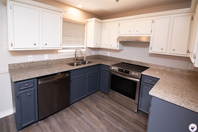 4718 Charleston St, Texarkana, AR 71854 - kitchen with stainless steel appliances, a sink, blue cabinetry, under cabinet range hood, and dark wood-style floors