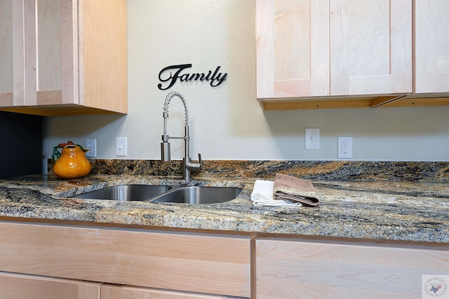 details with sink, light brown cabinets, and dark stone counters