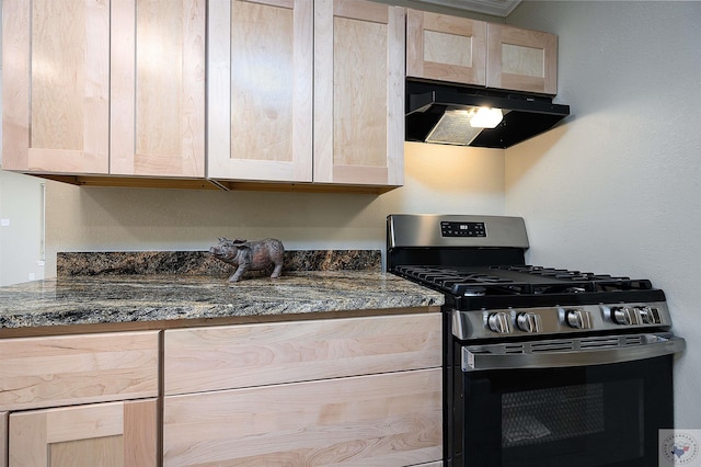 kitchen with stainless steel range with gas cooktop, light brown cabinets, and dark stone countertops