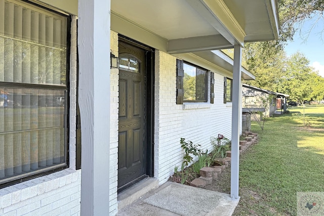 property entrance with a lawn