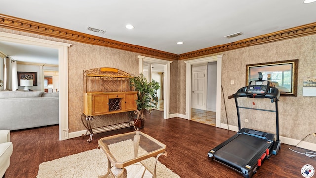 workout room with wood finished floors, visible vents, and crown molding