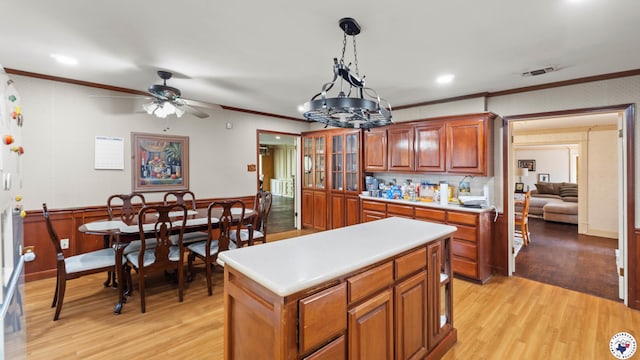 kitchen featuring light countertops, light wood finished floors, and ornamental molding