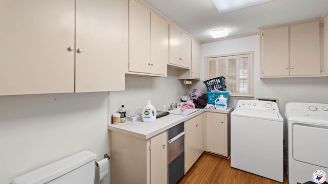 laundry area with washing machine and clothes dryer, a sink, light wood-style floors, and laundry area