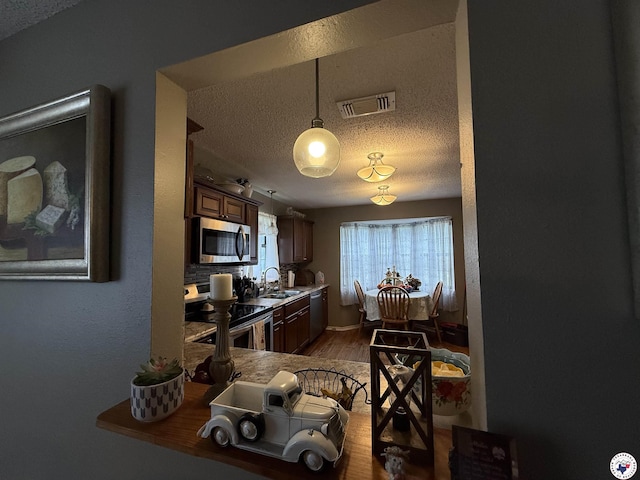 567 Mc 257, Texarkana, AR 71854 - kitchen featuring a textured ceiling, stainless steel appliances, dark wood-style flooring, and pendant lighting