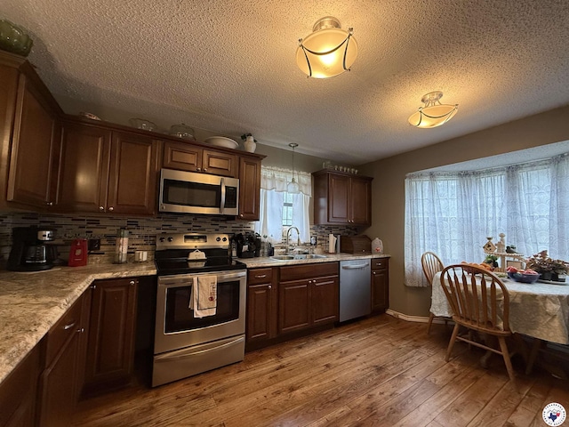 567 Mc 257, Texarkana, AR 71854 - kitchen featuring stainless steel appliances, light wood finished floors, a textured ceiling, backsplash, and light countertops