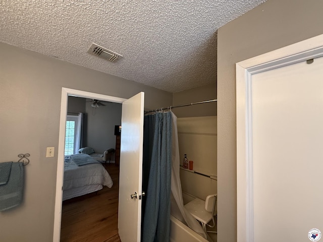 567 Mc 257, Texarkana, AR 71854 - bathroom with a textured ceiling, wood finished floors, ensuite bath, and shower / bath combination with curtain