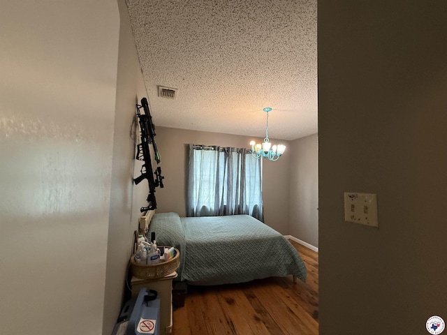 567 Mc 257, Texarkana, AR 71854 - bedroom featuring wood finished floors, a textured ceiling, and a chandelier