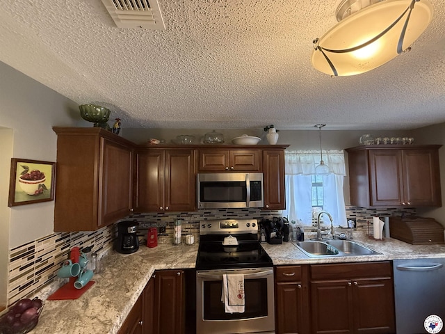 567 Mc 257, Texarkana, AR 71854 - kitchen featuring appliances with stainless steel finishes, tasteful backsplash, light countertops, a textured ceiling, and pendant lighting