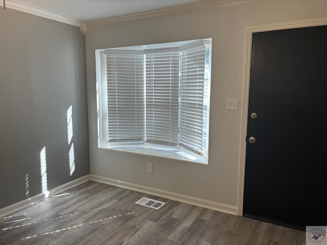 foyer with dark wood-type flooring, plenty of natural light, and crown molding