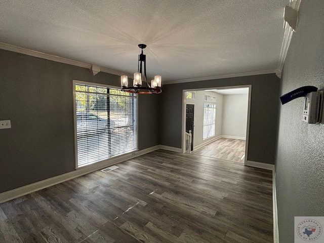 unfurnished dining area with crown molding, a healthy amount of sunlight, dark wood-type flooring, and a notable chandelier