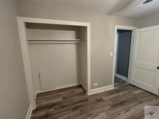 unfurnished bedroom featuring a closet, ceiling fan, and dark wood-type flooring