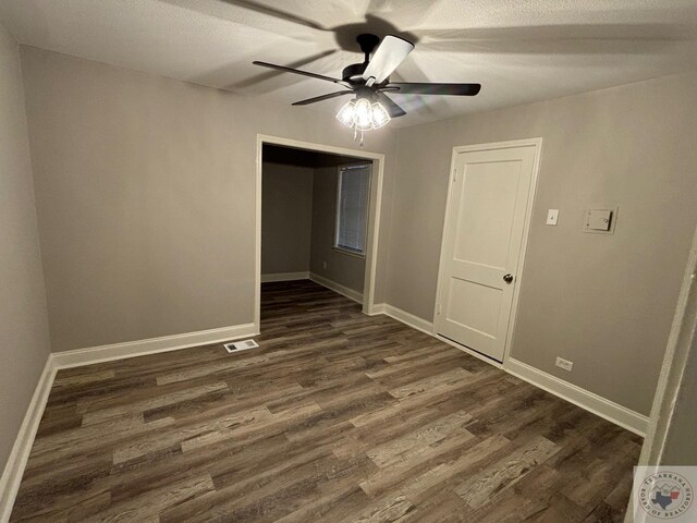 empty room featuring dark wood-type flooring and ceiling fan