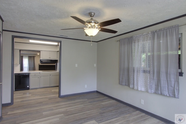 empty room with light hardwood / wood-style floors, a textured ceiling, crown molding, and ceiling fan