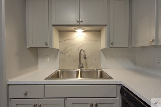 kitchen with sink, decorative backsplash, gray cabinetry, and dishwasher