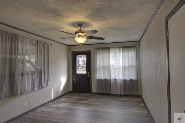 entryway with ceiling fan, dark wood-type flooring, a textured ceiling, and ornamental molding