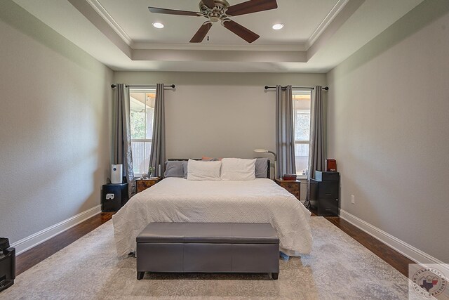 bedroom featuring a tray ceiling, baseboards, and ornamental molding