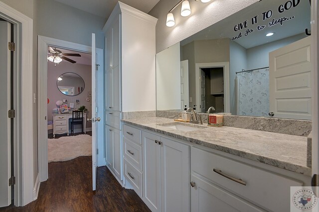 bathroom with a ceiling fan, wood finished floors, and vanity