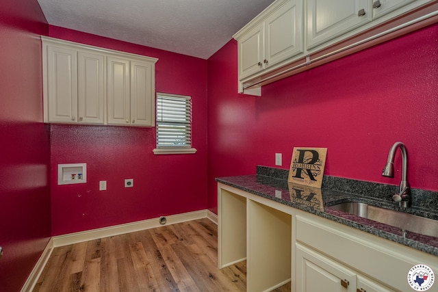 10 King Ranch Rd, Texarkana, TX 75503 - washroom with hookup for a washing machine, cabinet space, light wood finished floors, hookup for an electric dryer, and a textured ceiling