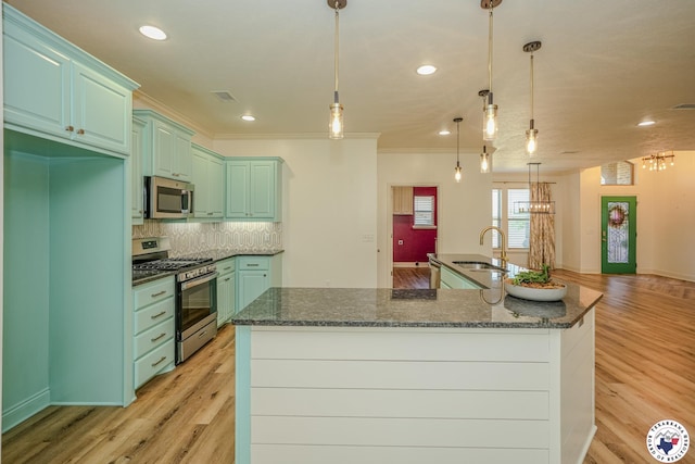 10 King Ranch Rd, Texarkana, TX 75503 - kitchen with appliances with stainless steel finishes, light wood-style flooring, tasteful backsplash, a large island with sink, and ornamental molding