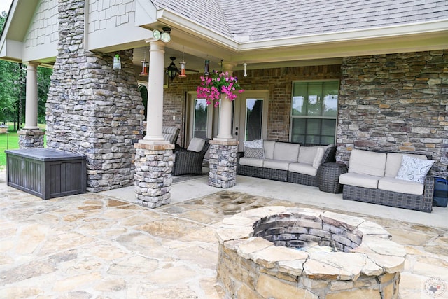 view of patio / terrace featuring ceiling fan and an outdoor living space with a fire pit