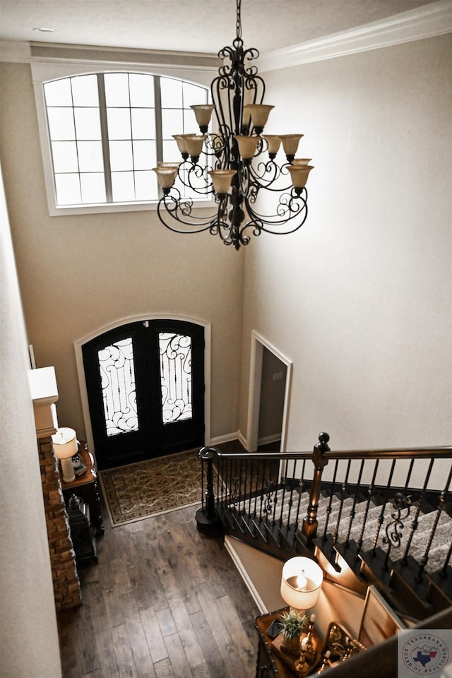 entrance foyer featuring crown molding, dark wood-type flooring, and a chandelier