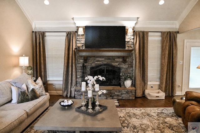 living room with crown molding, dark wood-type flooring, and a stone fireplace