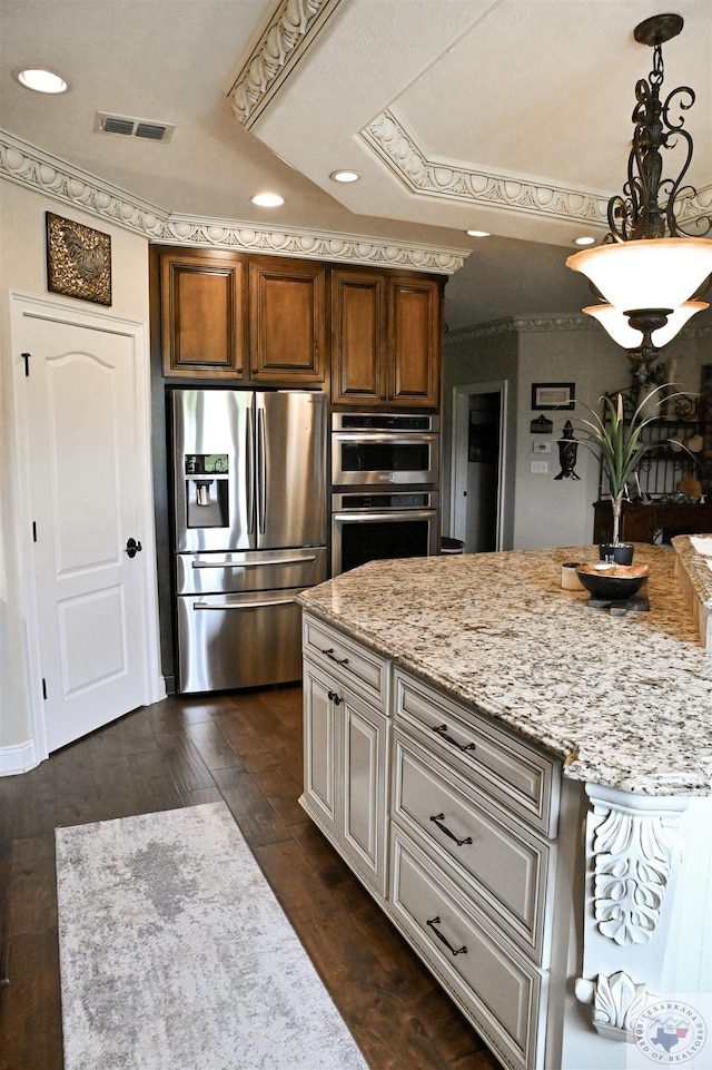 kitchen featuring crown molding, hanging light fixtures, dark hardwood / wood-style flooring, a raised ceiling, and stainless steel appliances