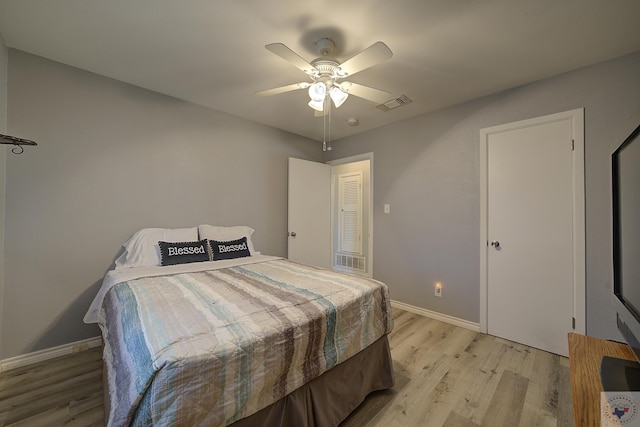 bedroom with light wood finished floors, visible vents, ceiling fan, and baseboards