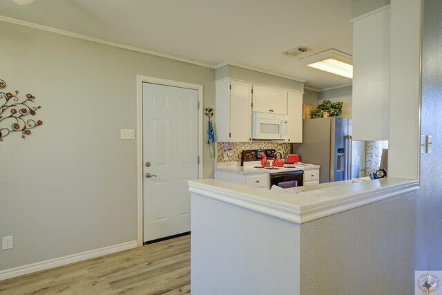 kitchen with white microwave, visible vents, ornamental molding, electric range oven, and stainless steel refrigerator with ice dispenser