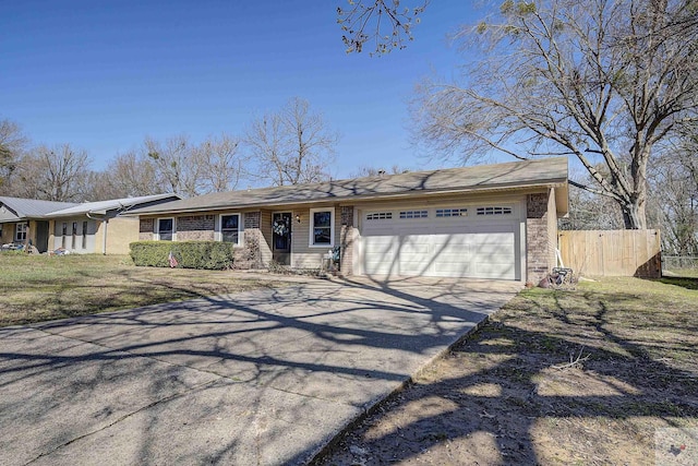 ranch-style home with fence, a garage, and driveway