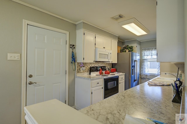 kitchen featuring white microwave, visible vents, tasteful backsplash, range with electric stovetop, and white cabinets