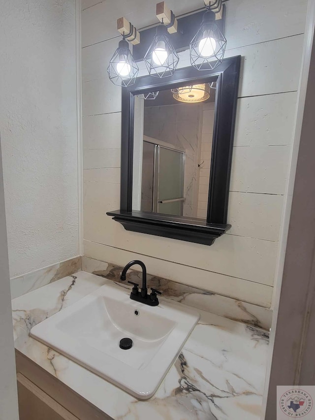 bathroom featuring vanity and wooden walls