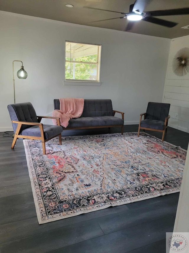 living area with ceiling fan, baseboards, and dark wood-type flooring