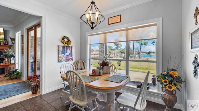 dining area featuring an inviting chandelier, dark tile patterned floors, baseboards, and crown molding