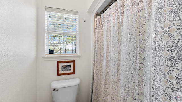 full bathroom with toilet and a shower with curtain