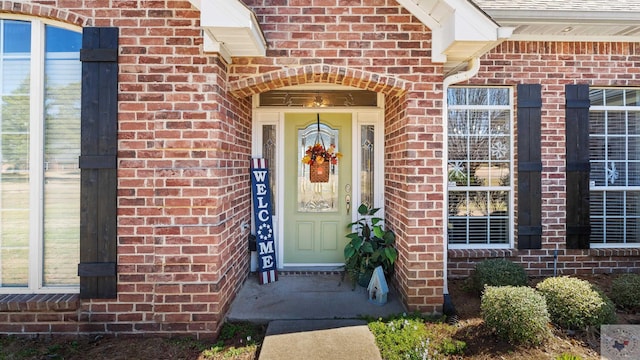 doorway to property featuring brick siding