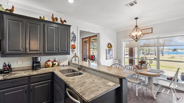 kitchen with a peninsula, visible vents, a sink, and ornamental molding