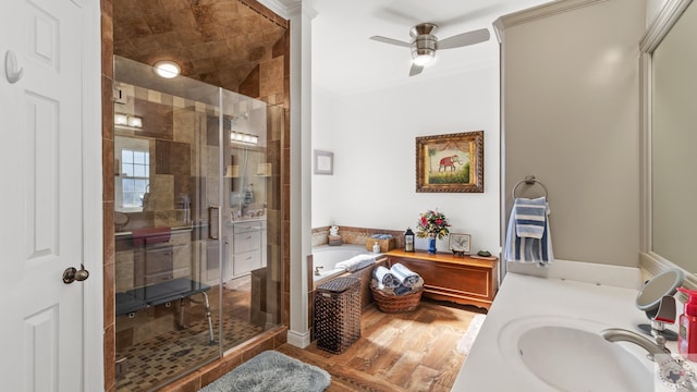 bathroom with a garden tub, wood finished floors, vanity, a ceiling fan, and a stall shower