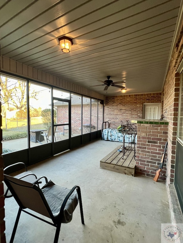 unfurnished sunroom with a ceiling fan