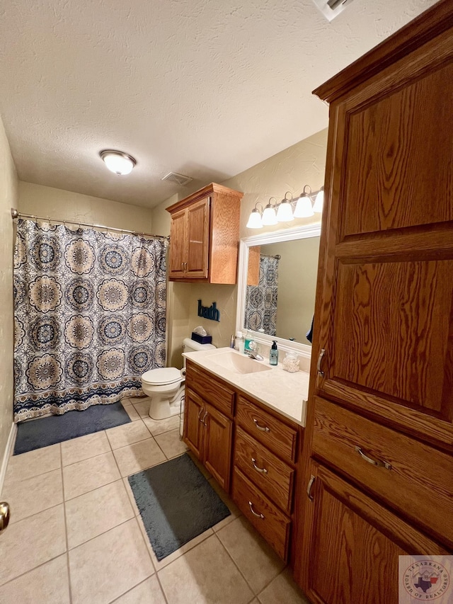 bathroom featuring visible vents, toilet, a textured ceiling, vanity, and tile patterned flooring