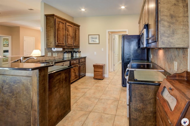 3705 Connie Ln, Texarkana, TX 75503 - kitchen featuring stainless steel microwave, dark countertops, tasteful backsplash, recessed lighting, and light tile patterned flooring