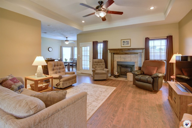 3705 Connie Ln, Texarkana, TX 75503 - living area featuring a raised ceiling, ceiling fan, wood finished floors, ornamental molding, and a tile fireplace