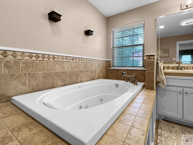 bathroom featuring tiled bath and vanity