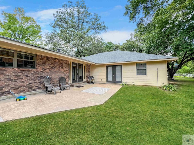 rear view of house featuring a patio area, a yard, and french doors